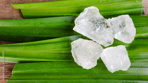 Crystal clear alum cubes or Potassium alum on green leaf. Chemical compound substance. Concept for beauty , spa and underarm treatment industrial.                                 photo