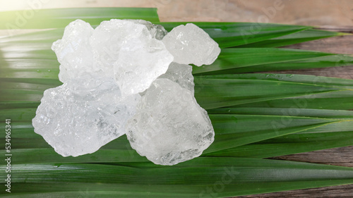 Crystal clear alum cubes or Potassium alum on green leaf. Chemical compound substance. Concept for beauty , spa and underarm treatment industrial.                                 photo