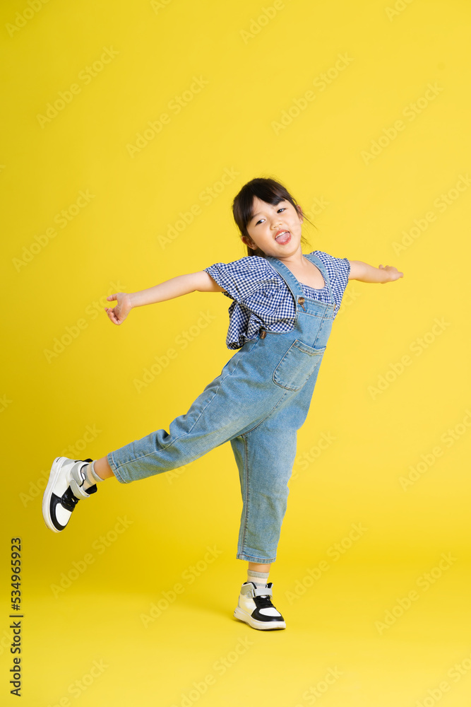 full body image of beautiful asian baby girl on yellow background full body image of beautiful asian baby girl on yellow background