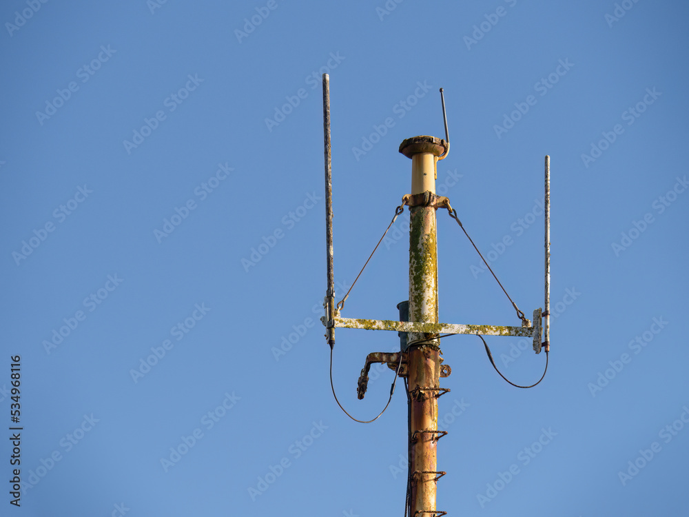 Rusty ship aerials on the mast. Blue sky. Rusty ship aerials on the mast. Blue sky.