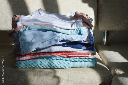 a stack of ironed clothes on the couch. household items. background for the design.