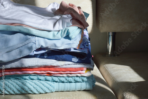 a stack of ironed clothes on the couch. household items. background for the design.