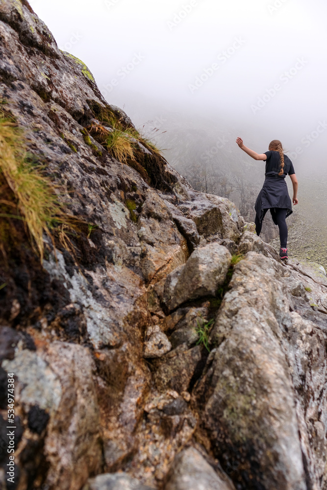 A mountaineer climbing the Polish Tatras in the white fog