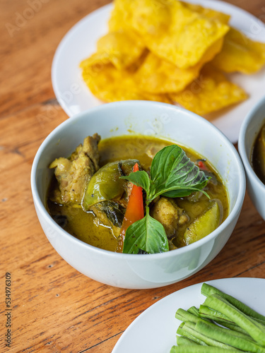 Thai green curry with chicken in a white bowl, selective focus.