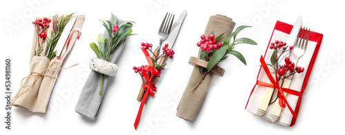 Set of cutlery with mistletoe for Christmas table setting on white background