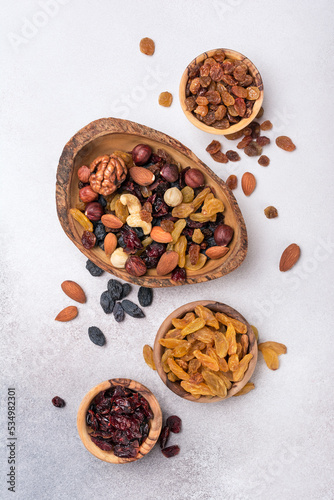 Wooden bowls with raisins, nuts and dried cranberries as ingredient for tasty dessert
