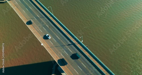 Cars on the bridge with one-direction road. Automobile bridge with pedestrian zone on the right. Top view. photo