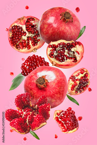 Tasty flying pomegranates on pink background