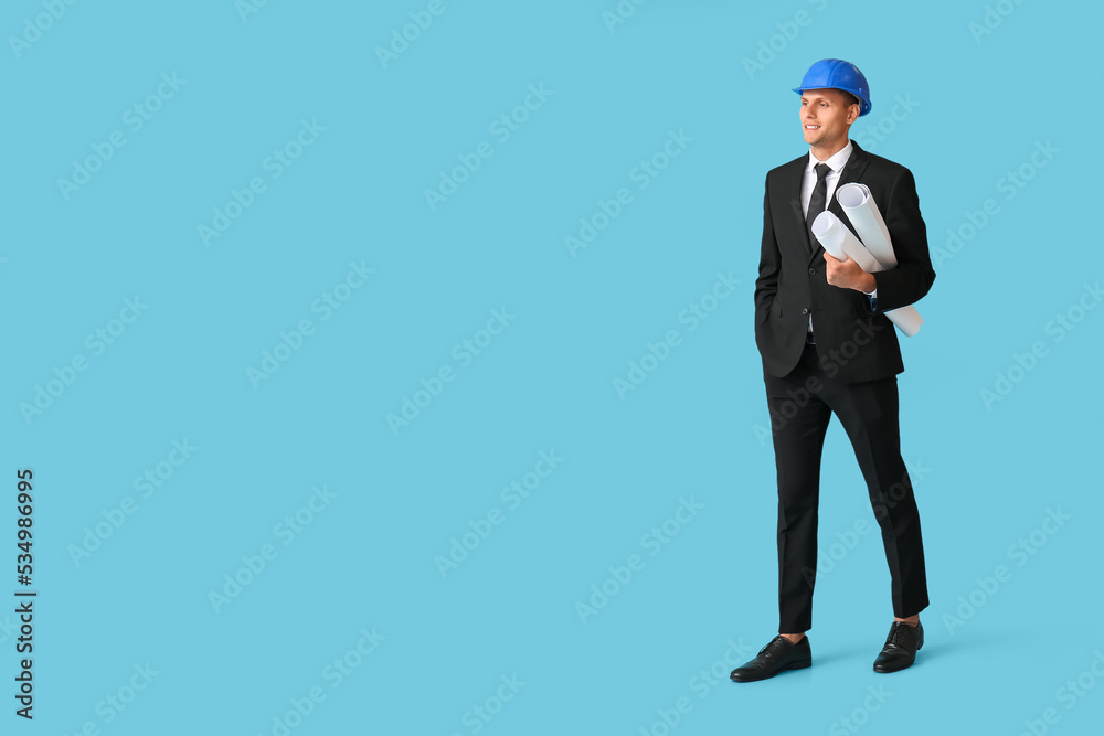 Young male architect with drawings on light blue background with space for text Young male architect with drawings on light blue background with space for text