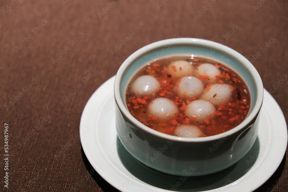close up a bowl of jiuniang yuanzi on table. Also called jiuniang tangyuan. Traditional Chinese sweet soup cuisine during the Dongzhi Festival close up a bowl of jiuniang yuanzi on table. Also called jiuniang tangyuan. Traditional Chinese sweet soup cuisine during the Dongzhi Festival