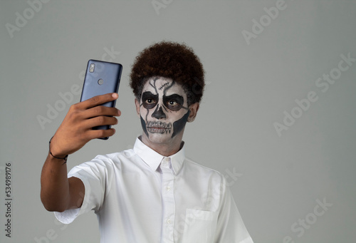 catrin teen with afro hair taking a selfie Santa muerte concept