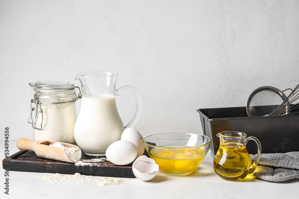 Ingredients for baking on white table against light background Ingredients for baking on white table against light background