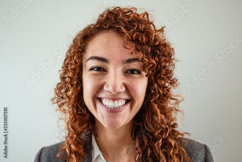 Business woman having fun looking in front of camera inside office