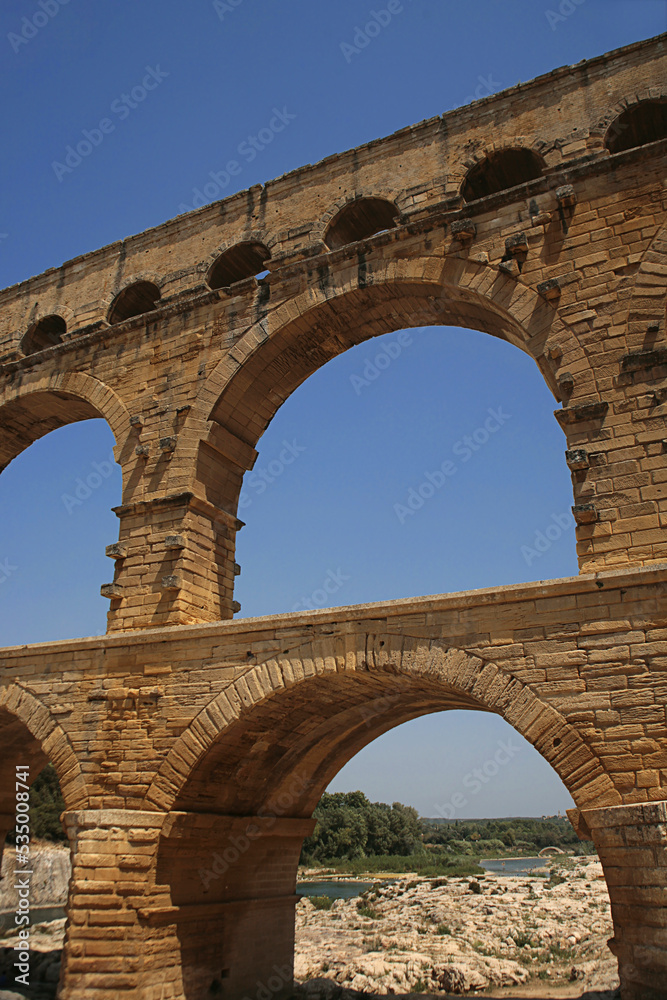 Pont du Gard, Gard, Occitanie, France: famous Roman aqueduct over Gardon river: close-up detail of the upper tiers of arches
