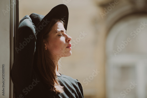 Beautiful girl face closeup, outside portrait of young woman in fashion hat. Summer romantic casual woman. Bright sun, summer, heat, travel and rest concept.