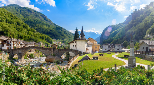 Lillianes, Aosta Valley. Italy. View of the stone bridge over the Lys stream, the Church of San Rocco and the cemetery. July 27, 2022. photo