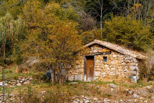 Abandoned stone house in the forest in autumn. Population abandonment of rural villages