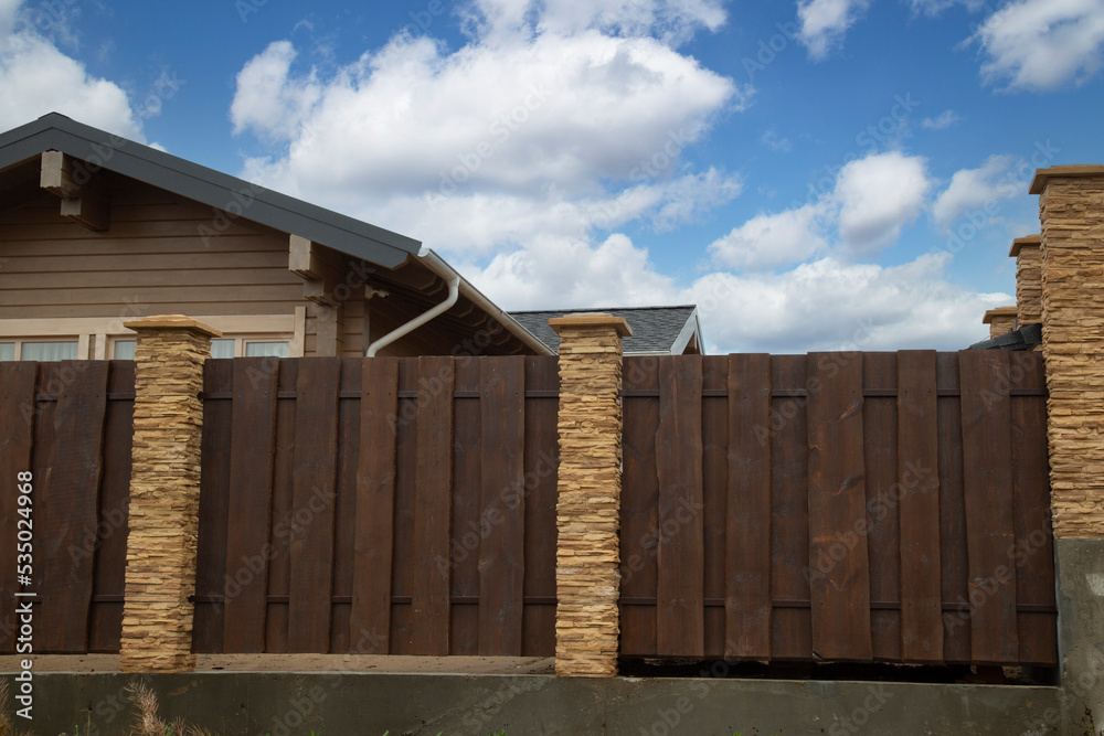 Modern fence around the house.Design and architecture of a modern house. Modern fence around the house.Design and architecture of a modern house.