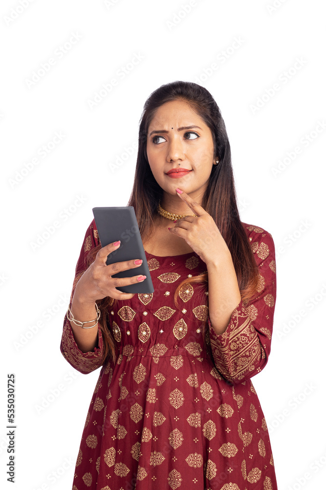 Indian young woman thinking while using smart phone. Indian young woman thinking while using smart phone.