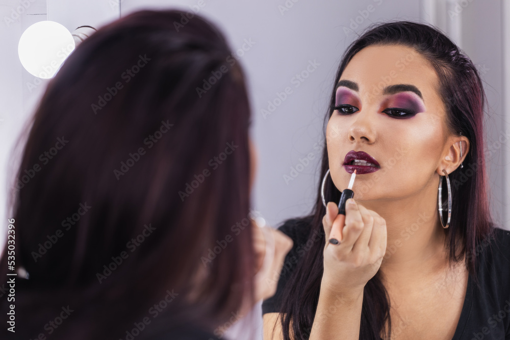 Woman Applying Lips Gloss In Front Of Mirror Woman Applying Lips Gloss In Front Of Mirror