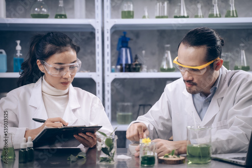 2 Researchers are grind the samples and taking notes in the laboratory. Young scientists are making beauty care products.