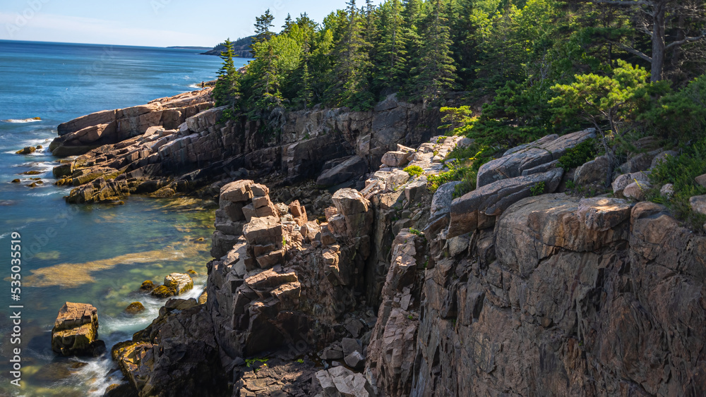 Cliffs Facing The Atlantic Ocean Landscape Creating A Breathtaking Scene With Combination Of Pine Trees, Sunlight, Ocean Shoreline and Clear Blue Sky
