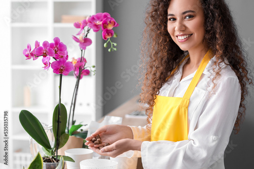 Young woman taking care of her orchid flowers at home photo