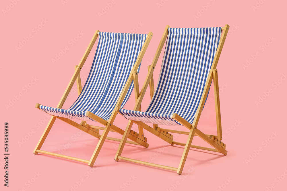 Beach deck chairs on pink background