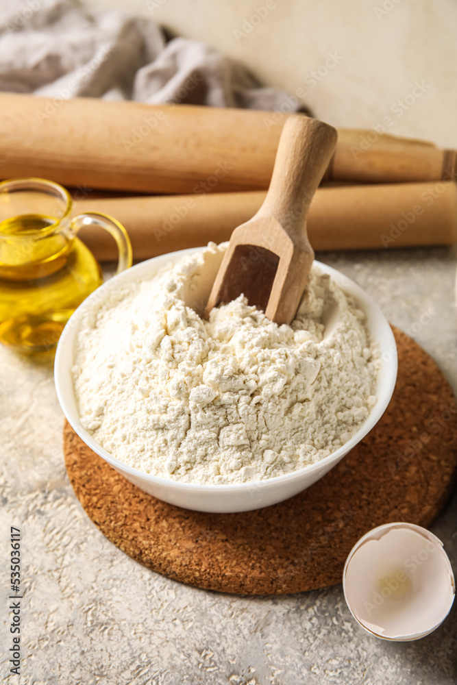 Bowl with flour and wooden scoop on table, closeup Bowl with flour and wooden scoop on table, closeup