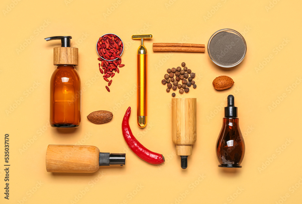 Naklejka premium Facial massage tool with cosmetic products and natural components on beige background