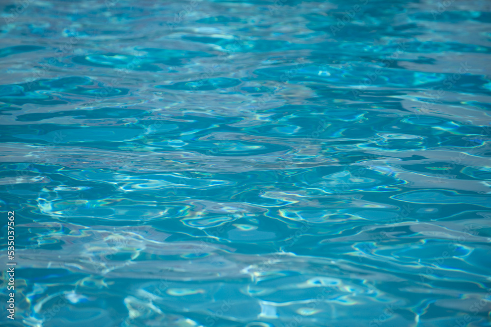 Background of blue water in swimming pool with sun reflection, ripple water wave in pool. Clear water background.