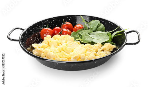 Frying pan with tasty scrambled eggs, tomatoes and greens on white background