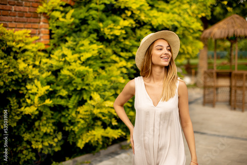 Young woman with hat walkin...