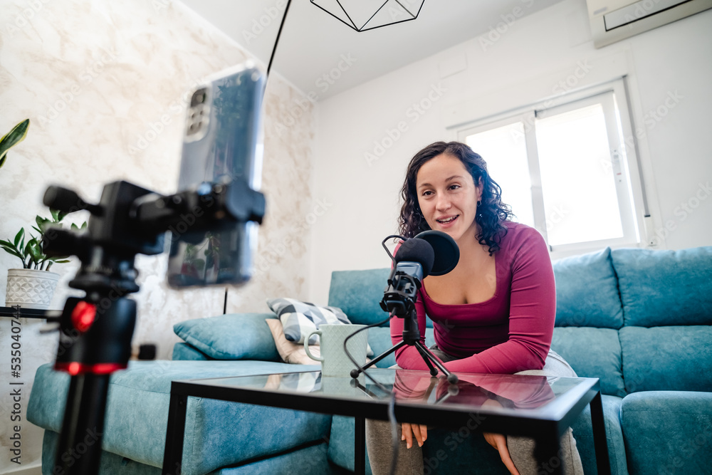 woman influencer filming with her cell phone in her living room