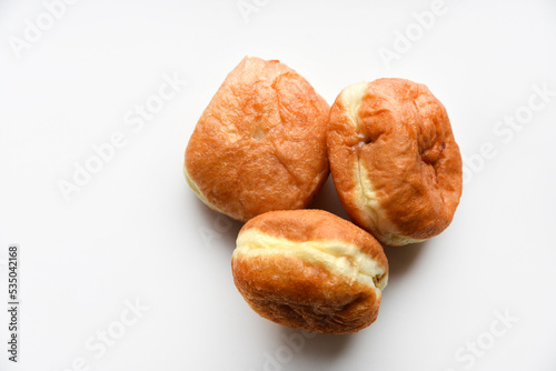 Delicious buns with jam on a white background. Sweet doughnuts with stuffing close-up.