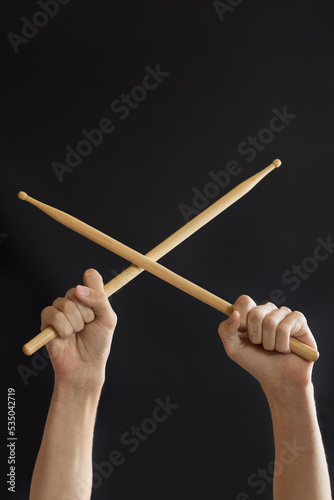 drumsticks in hands on a black background.