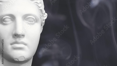 Greek sculpture of a woman made of white stone with swirling smoke