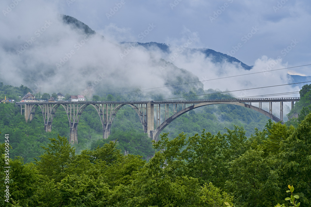 tall long bridge over the river in the mountains