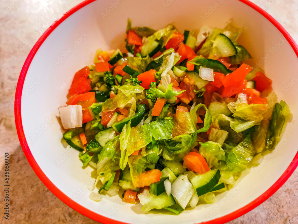 Bowl of salad with cucumber tomato greens broccoli Mexico.