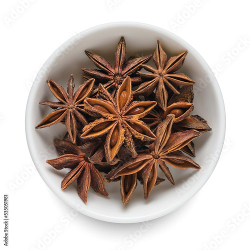 Anise star in white bowl isolated on white. Top view.