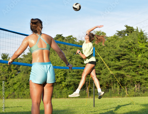 Volleyball player hitting the ball during a grass doubles game