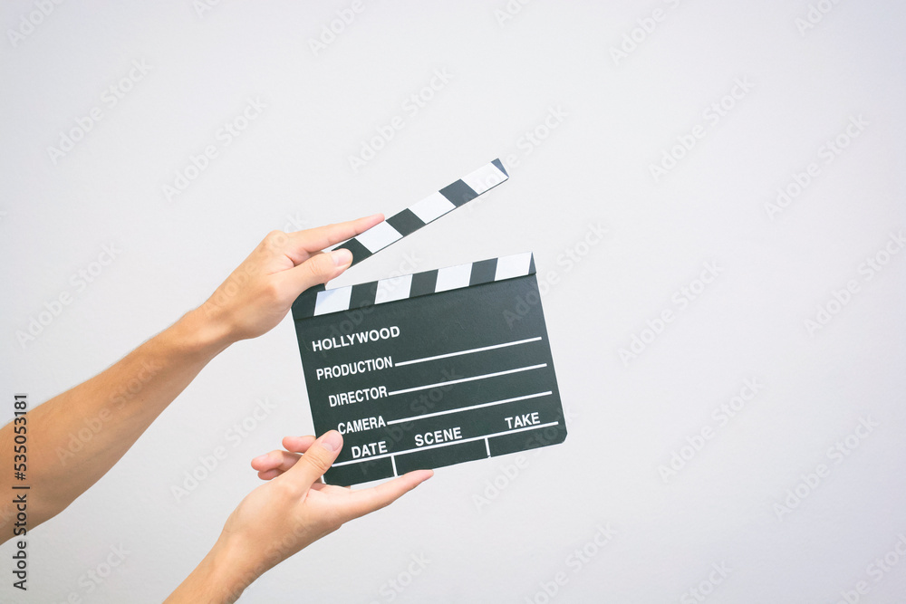 Hands holding a empty film making clapperboard or movie slate on a white background 