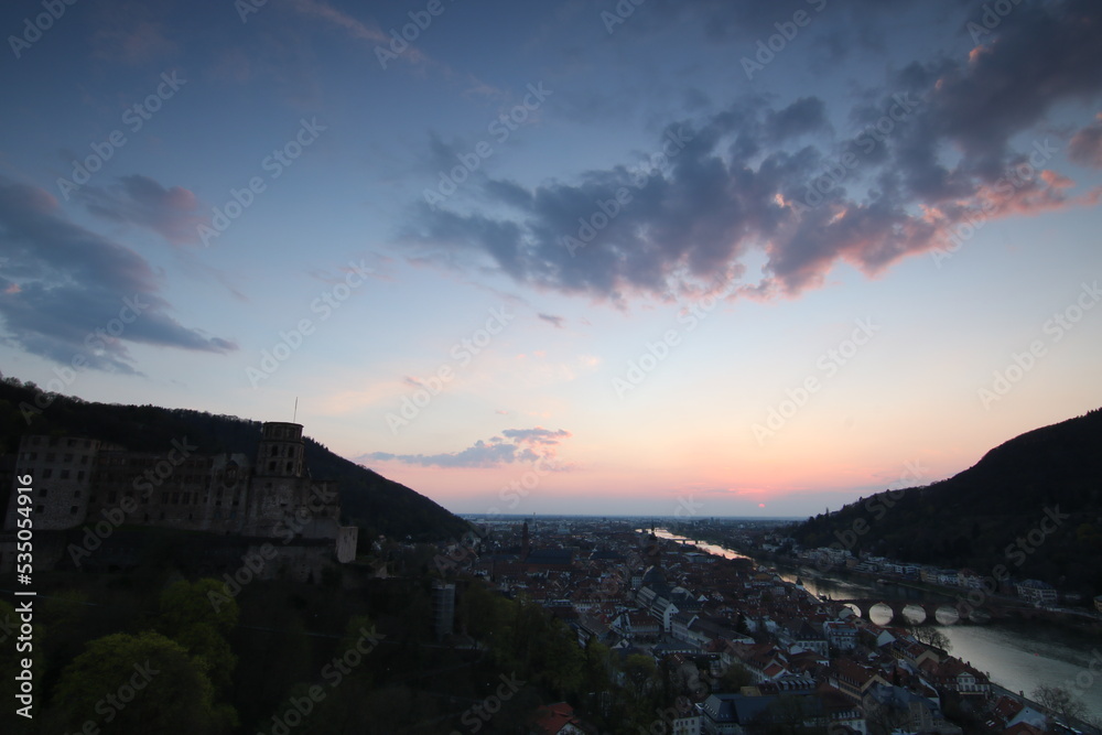 View over Heidelberg in the evening. Sunset on the horizon, view over the old town, the castle and the river Neckar on a warm summer day
