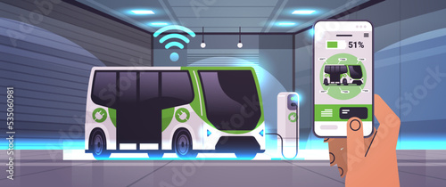 human hand charging electric bus in mobile app battery vehicle at recharging power station charger EV management