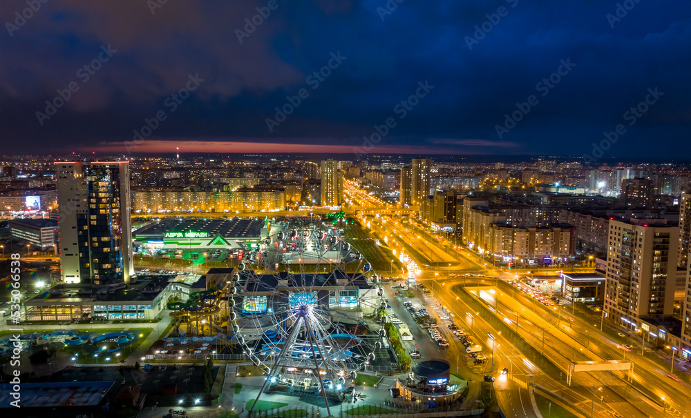 Panorama night city Kazan. View of the new quarters of new buildings and the Ferris wheel in the evening illumination