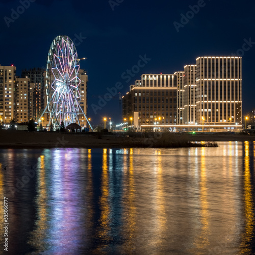 Panorama night city Kazan. View of the new quarters of new buildings and the Ferris wheel in the evening illumination