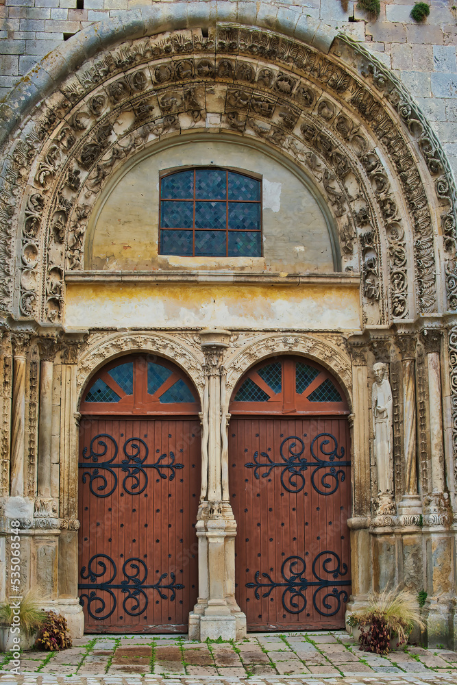 Obraz premium Beautifully decorated portal and double-door entrance to the medieval church of Notre Dame-Saint Lazare in Avallon, department of Yonne, France 