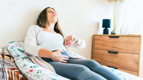 Pregnant clock time childbirth. Childbirth time, contractions pain. Pregnancy woman watching clock, holding baby belly. Pregnancy, medicine health care concept.