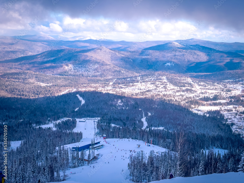 Winter landscape in Sheregesh ski resort in Russia, located in Mountain Shoriya, Siberia. Ski slopes and a view of the Sheregesh village Winter landscape in Sheregesh ski resort in Russia, located in Mountain Shoriya, Siberia. Ski slopes and a view of the Sheregesh village