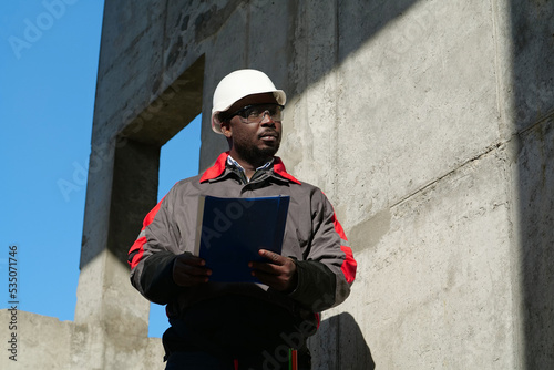 African american workman at construction site with work papers